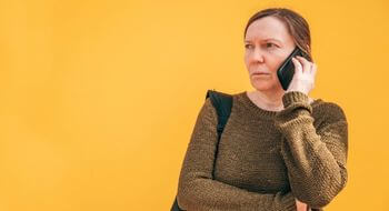 A woman is on the phone and looks concerned.